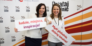 Radosne dziewczyny, trzymające tablice z&nbsp;hasłami. Pierwsza: ludzie, miejsca, inspiracje. Druga: Myśl globalnie, działaj lokalnie