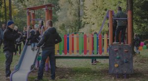 Plac zabaw Grupa rodziców i dzieci na zjeżdżalni na placu zabaw