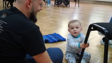 Tatuś siedzący na ziemi razem z synem