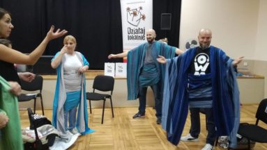Młodzi tatusiowie uczący się wiązać chusty.
