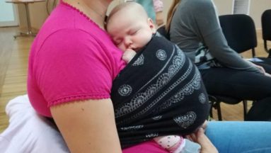 Młoda mama z noworodkiem w chuście.