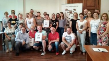 Zdjęcie przedstawia grupę osób pozujących na tle baneru "Działaj Lokalnie". Są to przedstawiciele realizatorów, którzy otrzymali dotację w ramach tegorocznego konkursu grantowego "Działaj Lokalnie" .