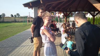 Zdjęcie przedstawia młodą kobietę udzielającą wywiadu dziennikarzowi z Radia Opole