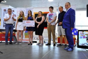 Zdjęcie przedstawia grupę odświętnie ubranych os&oacute;b. Jedna z&nbsp;nich trzyma symboliczny czek na&nbsp;grant programu Działaj Lokalnie.