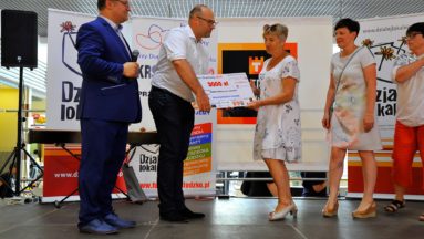 Na zdjęciu mężczyzna wręcza symboliczny czek na grant trzem kobietom z Kłodzkiego Stowarzyszenia "Amazonki".
