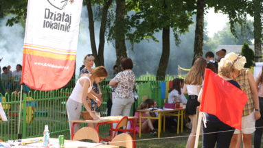 Zdjęcie przedstawia uczestników wydarzenia. W tle widać baner z logiem programu Działaj Lokalnie.