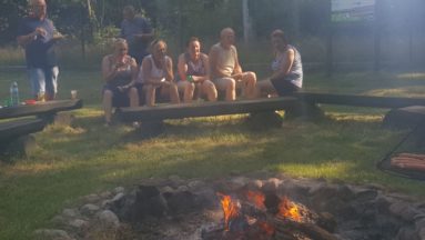 Zdjęcie przedstawia grupę uczestników rajdu, siedzących przy ognisku.