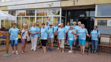 Zdjęcie przedstawia grupę seniorów, ubranych w koszulki z nazwą projektu, pozujących do zdjęcia.