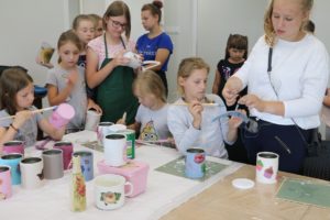 Zdjęcie przedstawia grupę dzieci i&nbsp;dorosłych podczas warsztat&oacute;w decoupage.