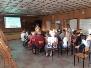 Zdjęcie przedstawia salę z&nbsp;publicznością oglądającą prezentację.