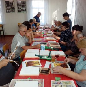 Warsztaty ikonograficzne Zdjęcie przedstawia uczestników warsztatów podczas pracy nad ikonami.