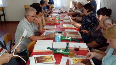 Zdjęcie przedstawia uczestników warsztatów podczas pracy nad ikonami.