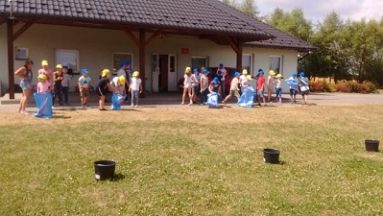 Zdjęcie przedstawia dzieci biorące udział w zabawach w ogrodzie.
