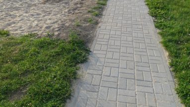 Zdjęcie przedstawia chodnik wyłożony nową kostką brukową.