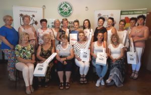 Zdjęcie przedstawia grupę os&oacute;b trzymających dyplomy i&nbsp;pozujących do&nbsp;zdjęcia.