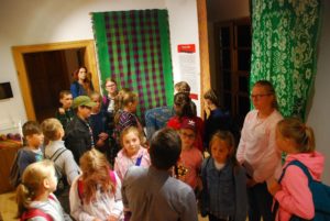 Podlaskie Muzeum Kultury Ludowej Zdjęcie przedstawia grupę dzieci podczas oprowadzania po muzeum.