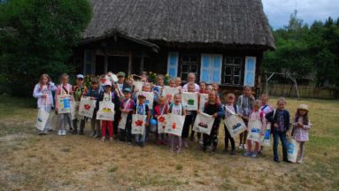 Zdjęcie przedstawia uzcestników projektu pozujących z wykonanymi przez siebie torbami.