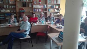 Zdjęcie przedstawia osoby słuchające wykładu w&nbsp;bibliotece.