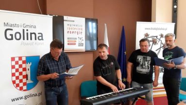Zdjęcie przedstawia cztery osoby podczas próby chóru.