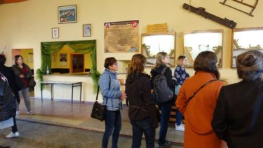 Zdjęcie grupy osób oglądających gabloty z tradycyjnymi narzędziami stolarskimi