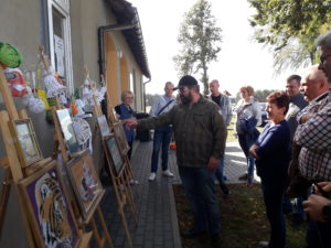 Na zdjęciu widać plenerową wystawę prac plastycznych i&nbsp;widz&oacute;w.