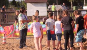 Zabawy plażowe Zdjęcie przedstawia osoby stojące w grupie na plaży podczas jednej z zabaw.