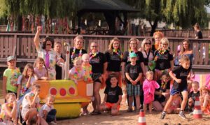Łódź podwodna - instalacja do robienia zdjęć Zdjęcie przedstawia grupę osób pozujących do zdjęcia na plaży, przy instalacji - rzeźbie żółtej łodzi podwodnej.