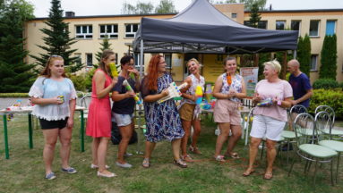 Zdjęcie przedstawia grupę ludzi na imprezie plenerowej.