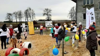 Zdjęcie przedstawia rodziny na nowo otwartym placu zabaw.