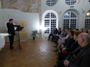 Koncert Zdjęcie przedstawia muzyka podczas koncertu w oranżerii