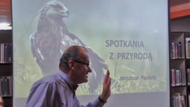 Na zdjęciu widać prelegenta na tle prezentacji na której znajduje się napis: Spotkania z przyrodą