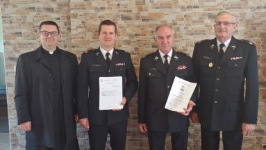 Zdjęcie przedstawia osoby pozujące do zdjęcia z podpisanymi umowami.