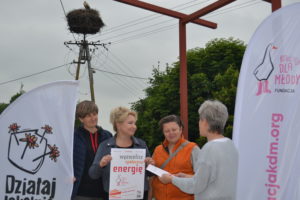 Centrum Kożuchowa Zdjęcie przedstawia osoby w plenerze, podpisujące umowy.