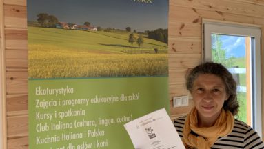 Na zdjęciu osoba trzyma podpisaną umowę i pozuje do zdjęcia.