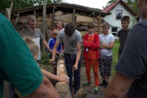 Uczestnicy projektu sprawdzają swoje siły w&nbsp;heblowaniu drzewa, kt&oacute;re&nbsp;będzie wykorzystane do&nbsp;budowy pojazdu Flinston&oacute;w.