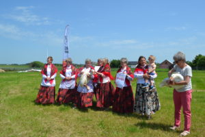 Zdjęcie przedstawia grupę os&oacute;b w&nbsp;plenerze, ubraną w&nbsp;tradycyjne stroje.