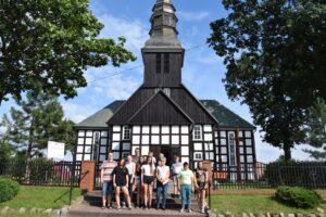 Grupa pozuje do&nbsp;zdjęcia przed kościołem