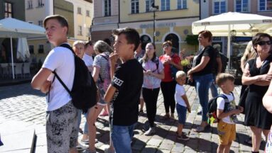 Uczestnicy stoją na rynku w Poznaniu