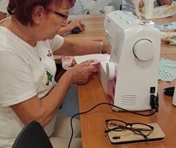 Seniorka szyje na maszynie