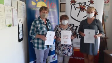 Grupa grantobiorców pozuje do zdjęcia pokazując podpisane umowy