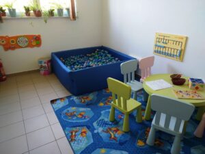 Zdjęcie przedstawia kącik zabaw - basen z&nbsp;kulkami, stolik, krzesła, dywan