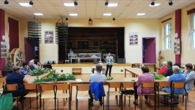 Grupa osób w sali podczas prelekcji