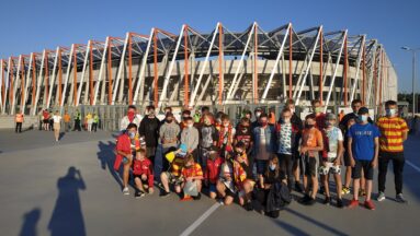 Grupa dzieci pozuje do zdjęcia przed stadionem w Białymstoku