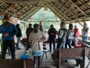 Spotkanie w ramach projektu "Z naturą silniejsi" Grupa osób stoi pod wiatą i słucha prelegentki