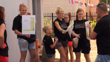 Grupa mieszkańców pozuje do zdjęcia w plenerze