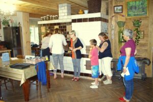 Tradycyjny piec z plitą Grupa osób stoi przy tradycyjnym piecu