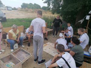 Grupa dzieci i&nbsp;młodzieży układa puzzle w&nbsp;plenerze