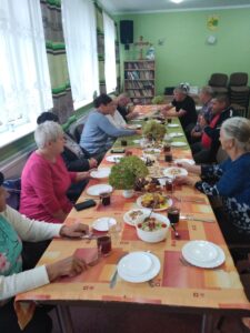 Uczestnicy spotkania Osoby siedzą przy stole podczas posiłku