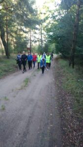 Wyprawa 07 wrzesnia Na zdjęciu grupa osób maszeruje w lesie